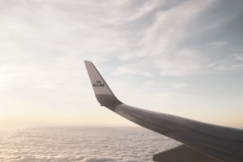 Flugzeugflügel über den Wolken bei Sonnenuntergang