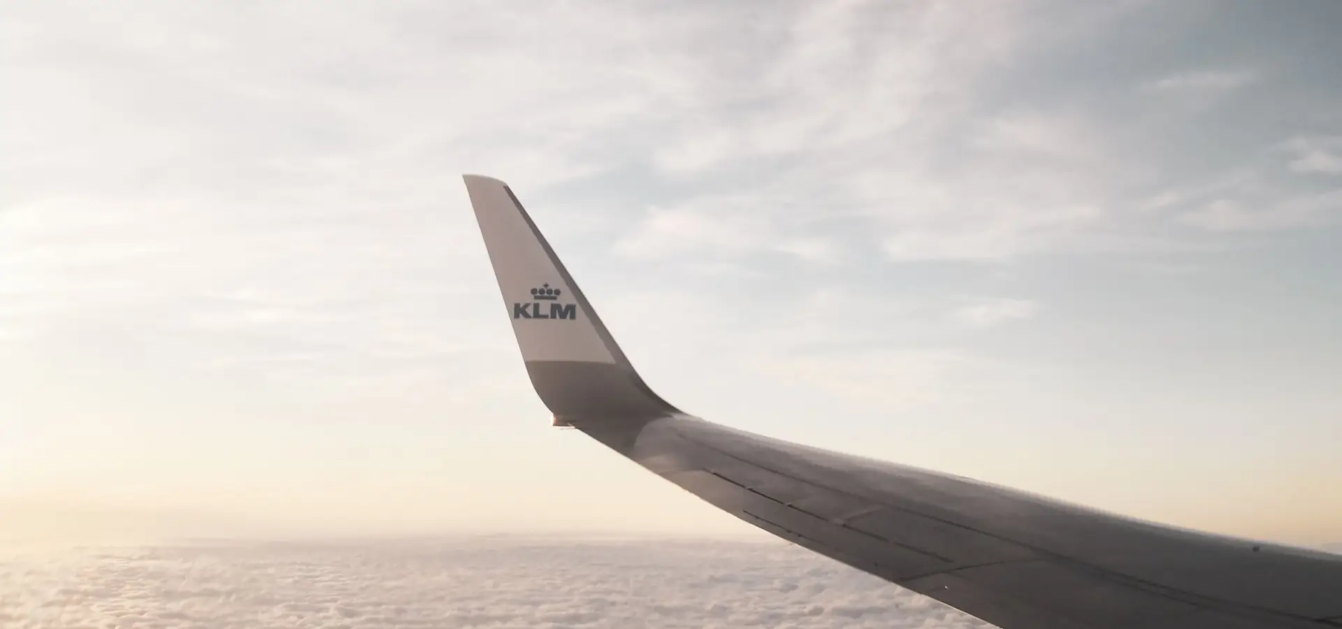 Flugzeugflügel über den Wolken bei Sonnenuntergang